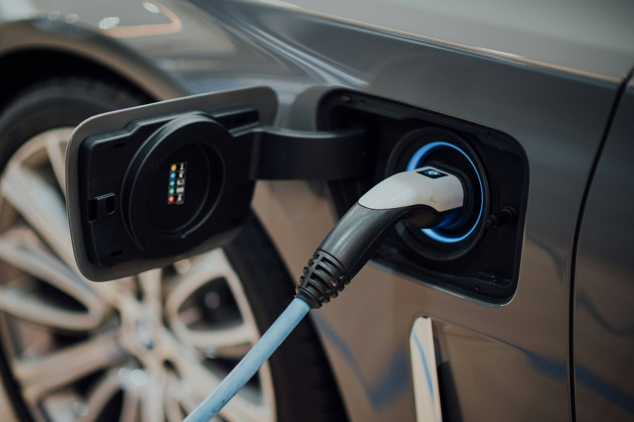 A charging cable plugged into the port of an electric car