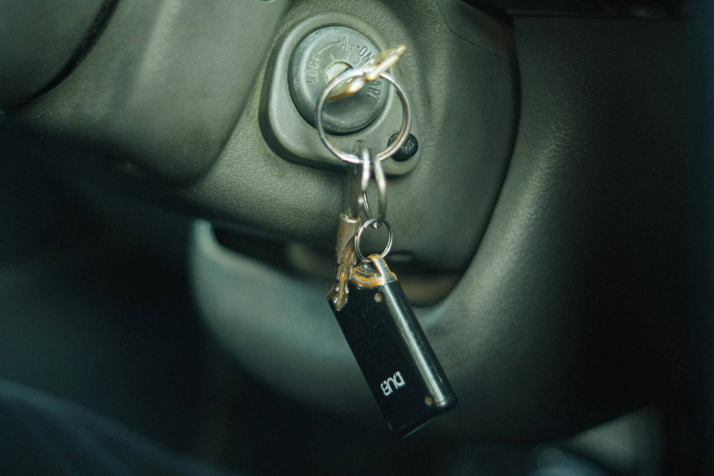 A car key on a keychain hanging from a door handle